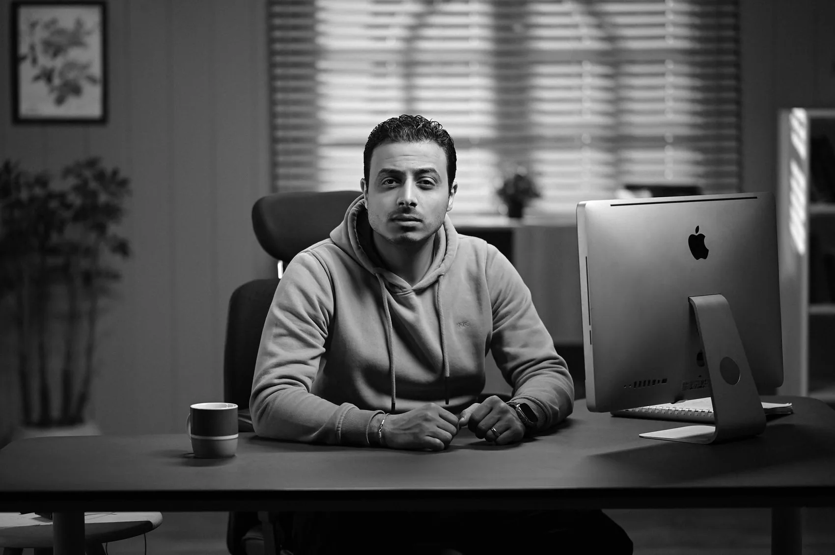 Andrew Fathi at his desk, black and white